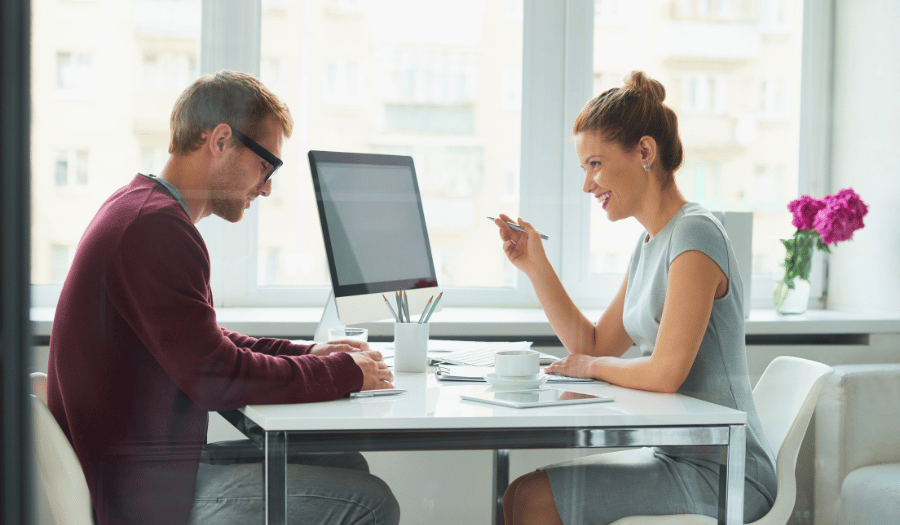 Two professionals discussing sensitive information at a desk, representing secure document sharing and protected communication with Mailock