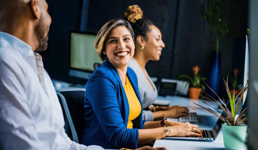 Customer service agent smiling in office with colleagues using Mailock