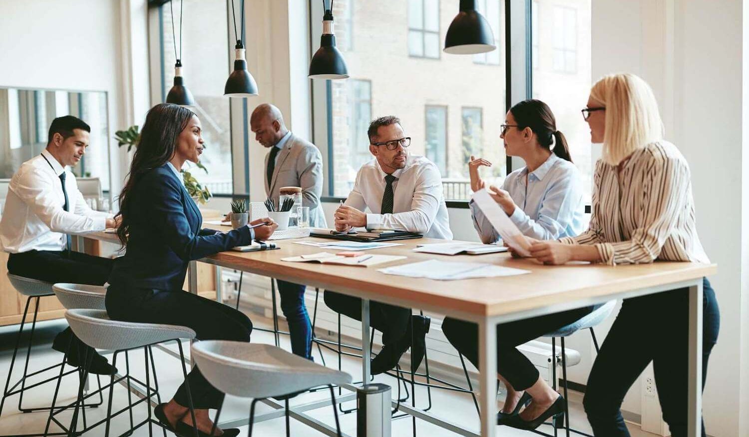 Financial advisers sitting around table in a modern office discussing secure emailing options