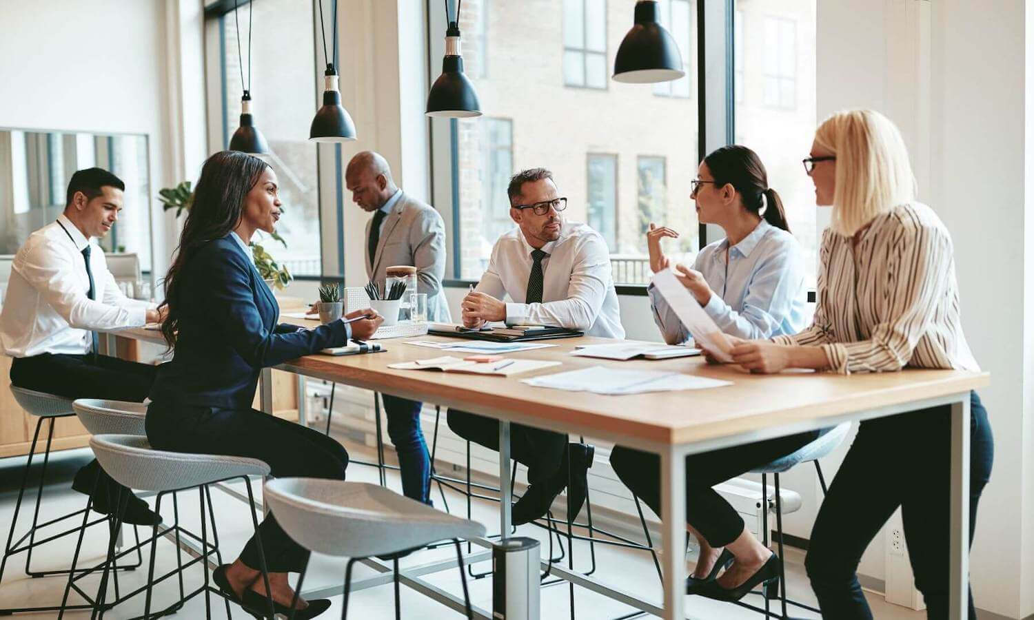 Financial advisers sitting around table in modern office discussing security
