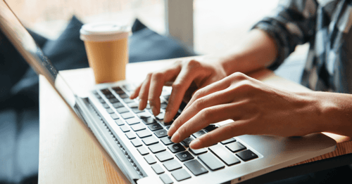 Person typing on a laptop while travelling