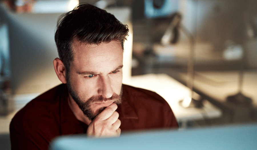 IT manager reviewing information security protocols for secure email sending in office at night
