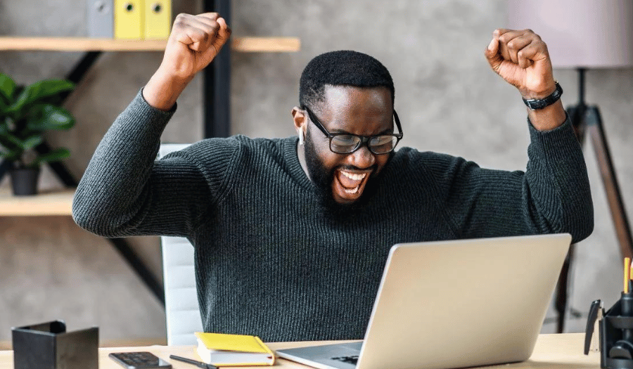 Male professional celebrating after sending a successful secure email to his clients