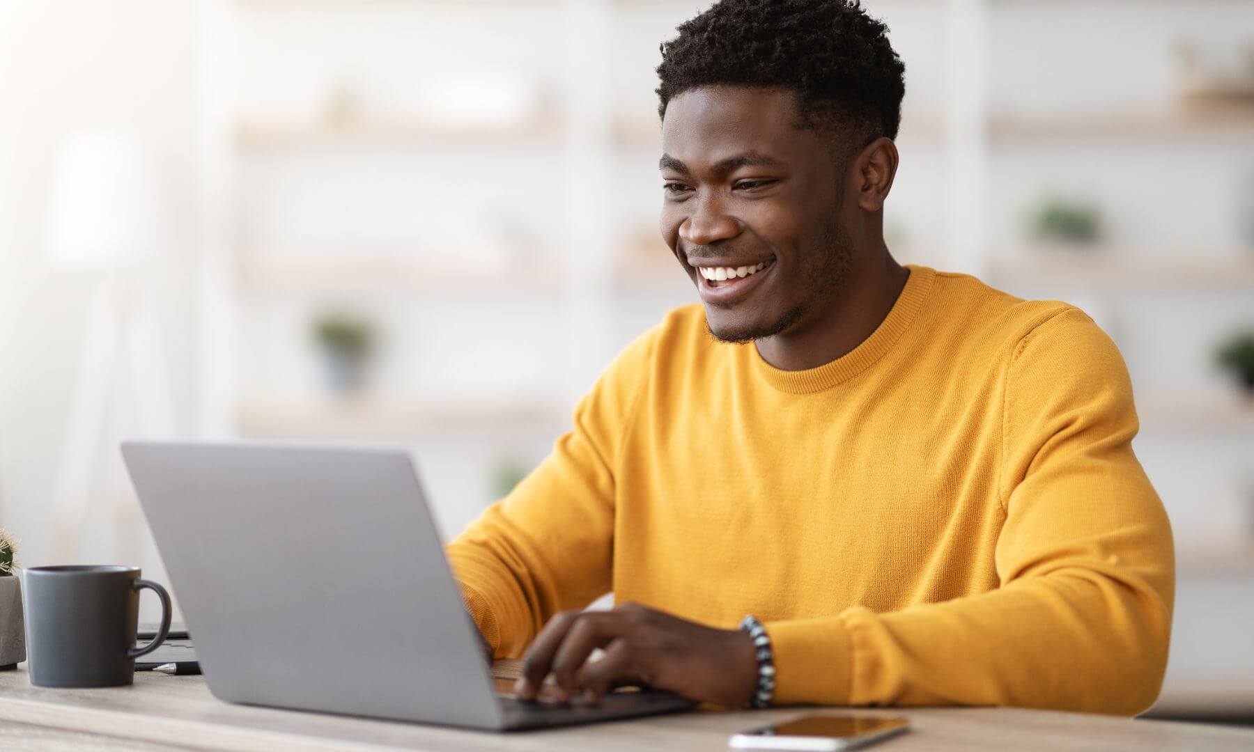 Man in office securing email and smiling with a coffee cup