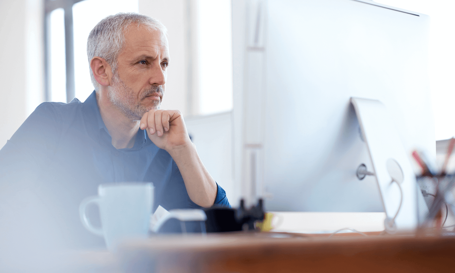 Man looking at computer and smiling slightly