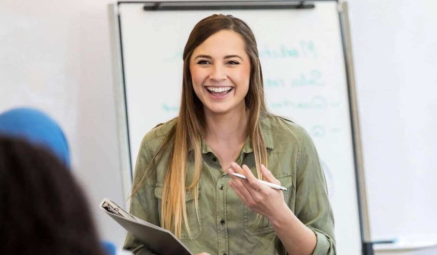 Trainer at office training with clipboard smiling