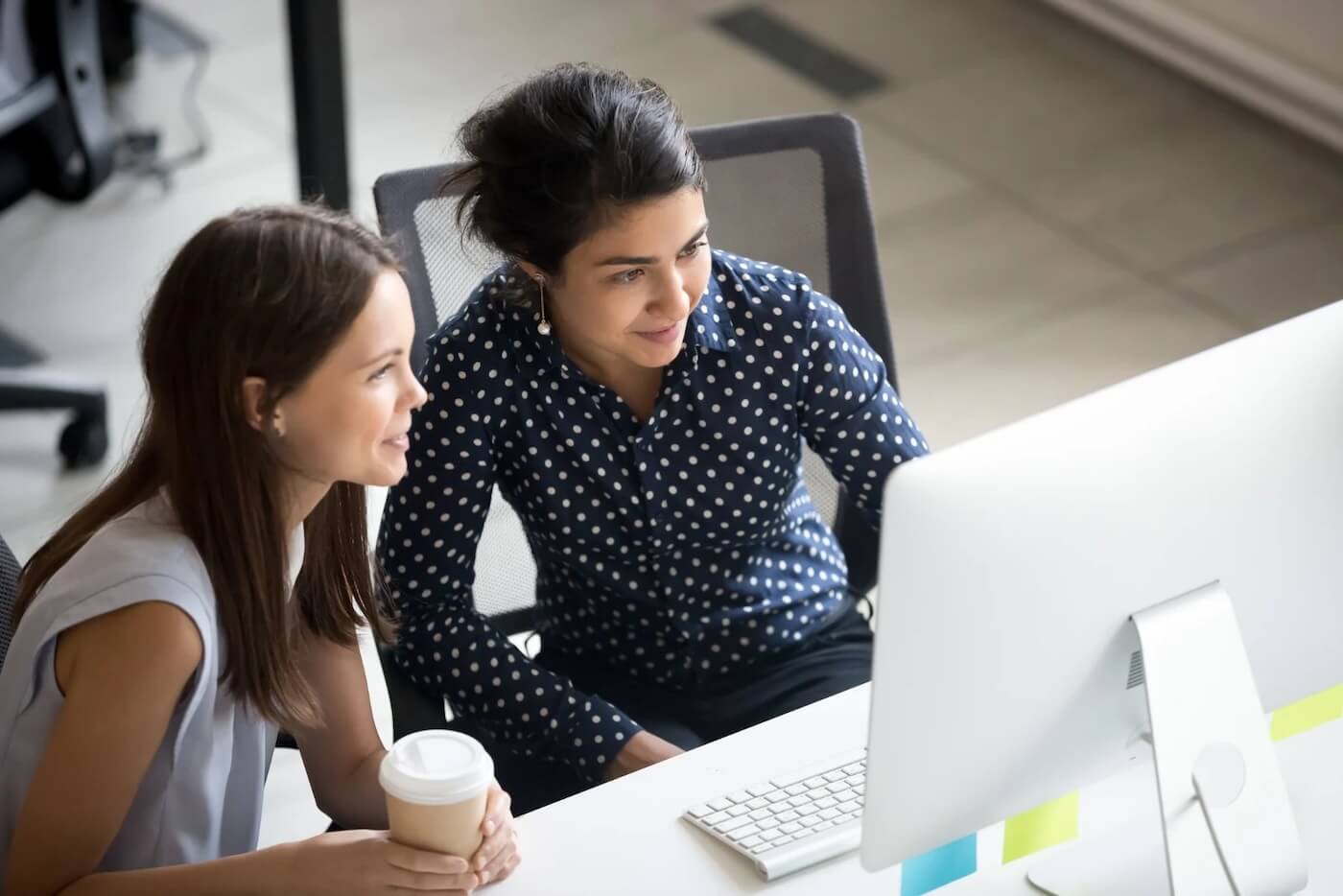 Woman looking at office computer together in a secure email demo