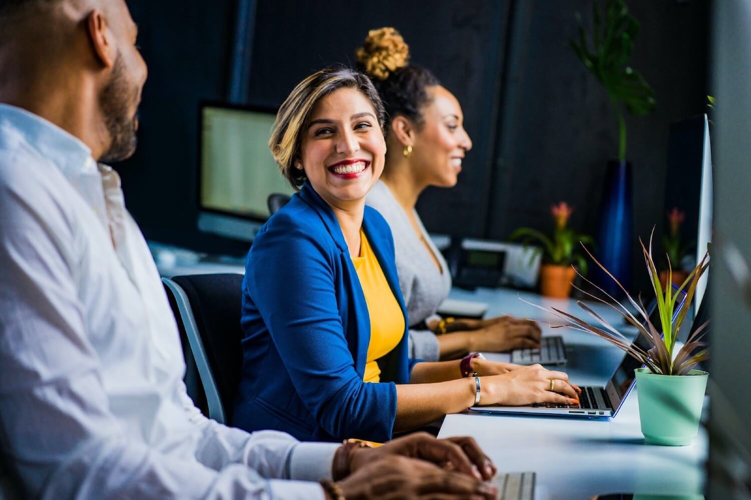 Customer service team collaborating at computers, representing secure customer communications and protected email workflows with Mailock
