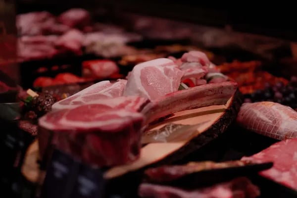 Cuts of raw meat on display in a butcher's counter