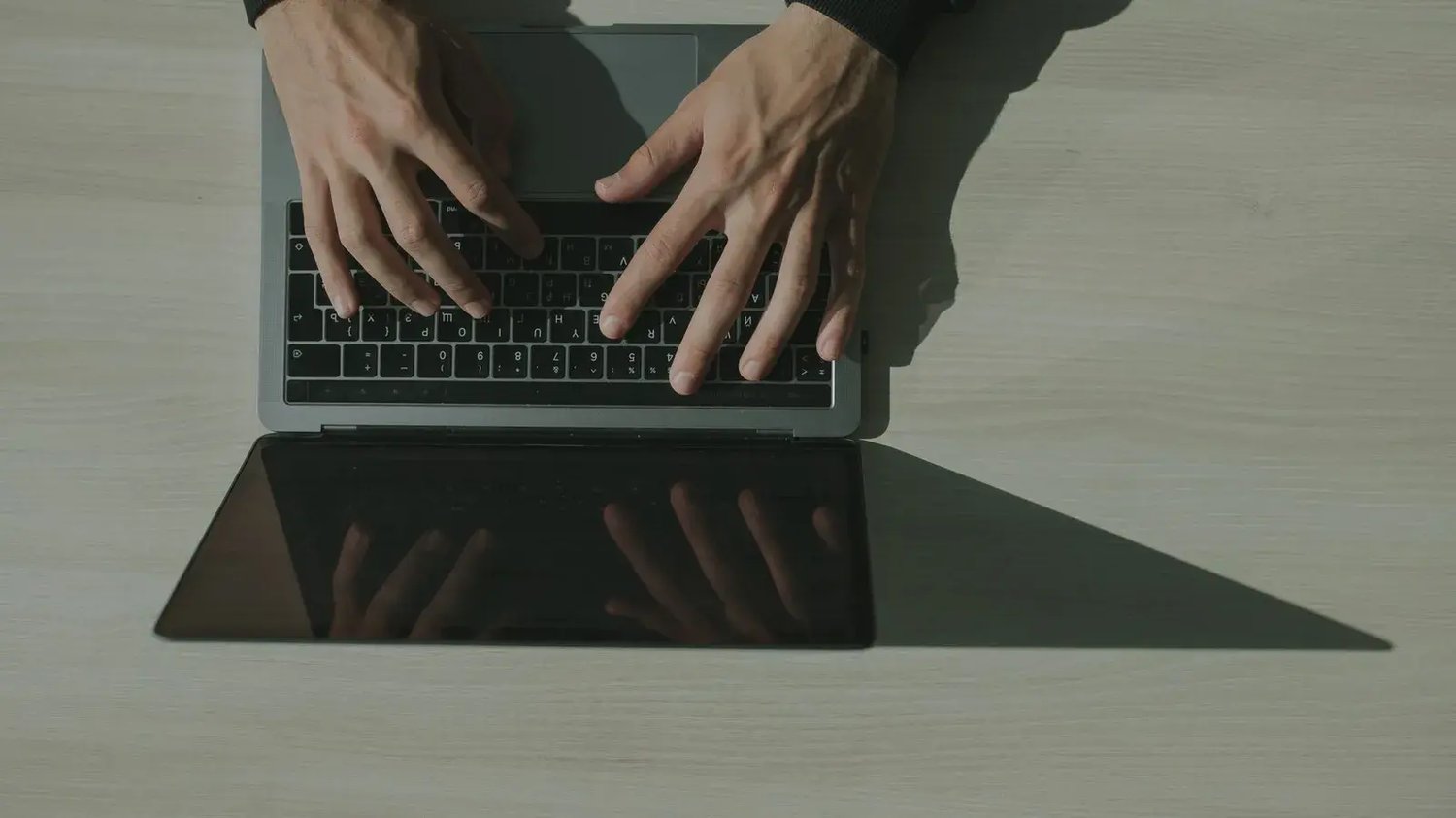 Hands typing on a laptop