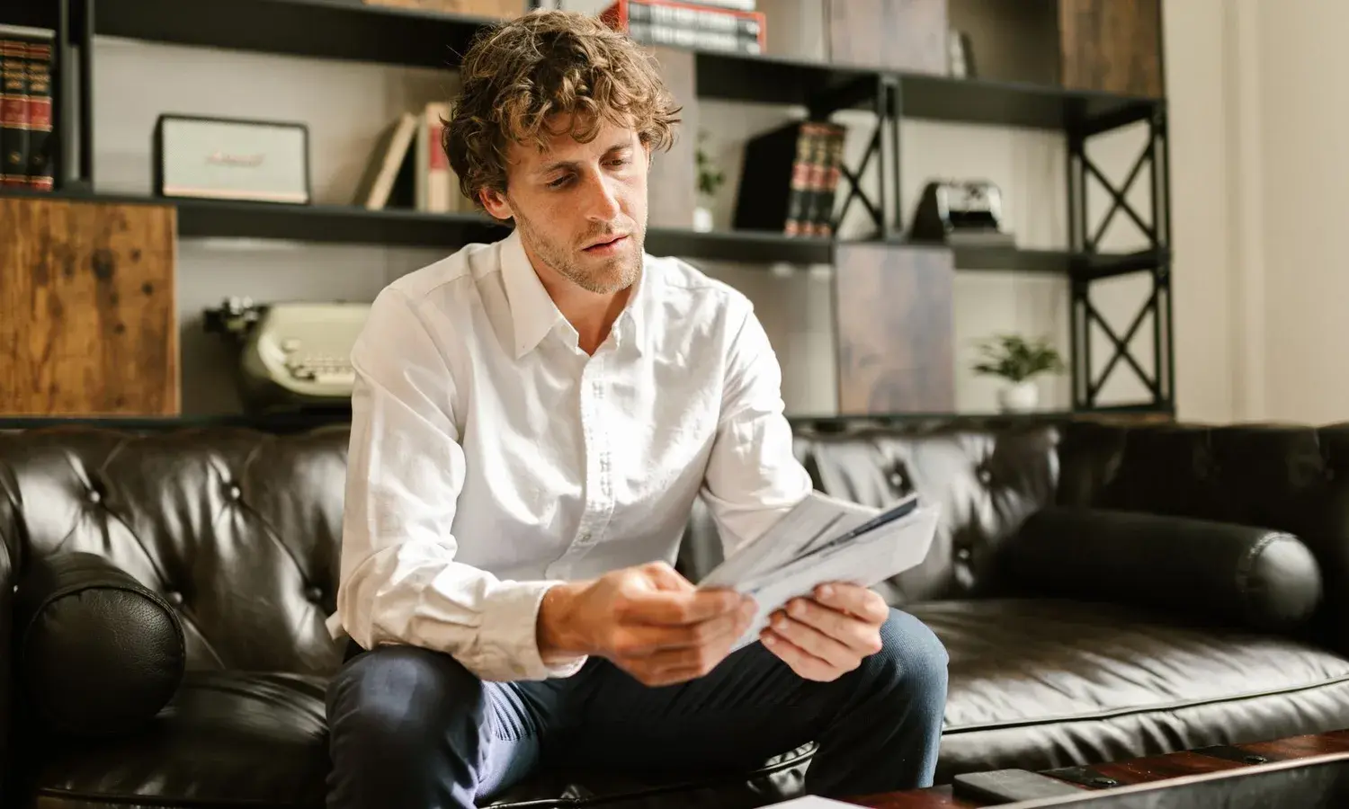A person reading a printed statement at home