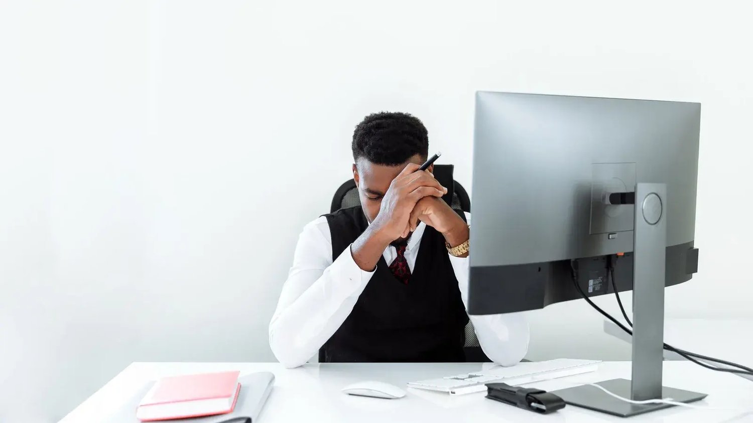 A stressed professional at an office computer