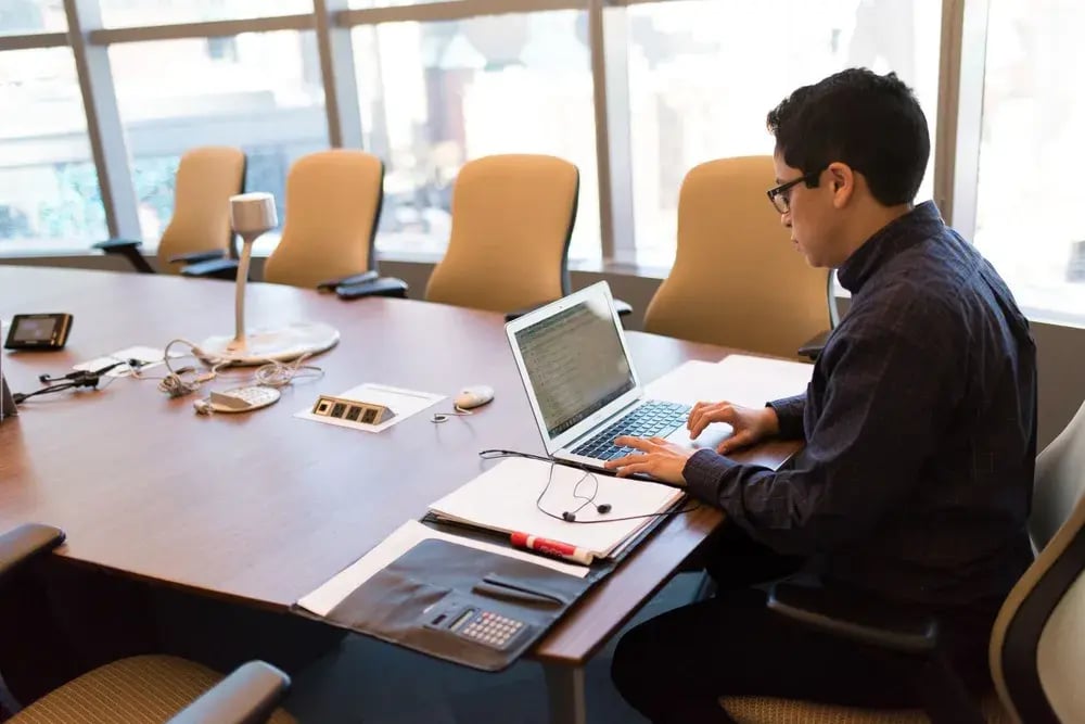 A professional using a laptop in a meeting room