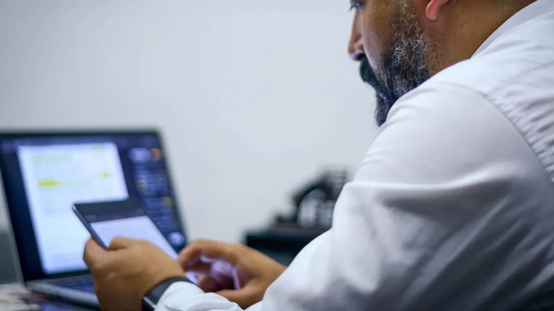 A professional checking a secure email on a phone and laptop