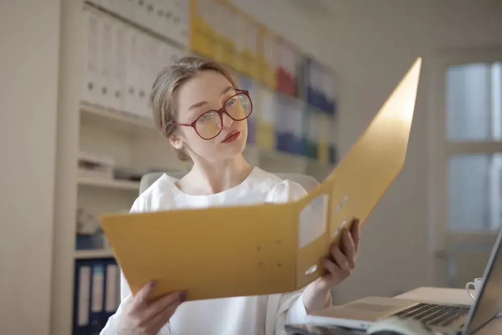 Person reviewing documents from a folder in an office