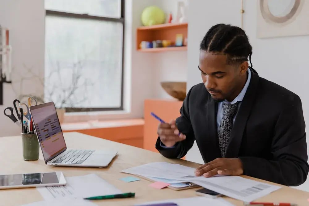 Professional reviewing documents at a desk in an office
