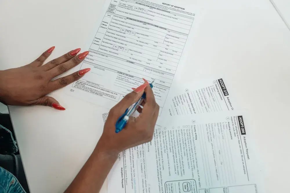 Person filling out a paper form by hand