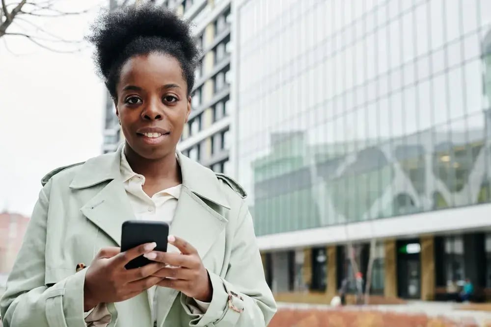 Professional using a smartphone outside an office building