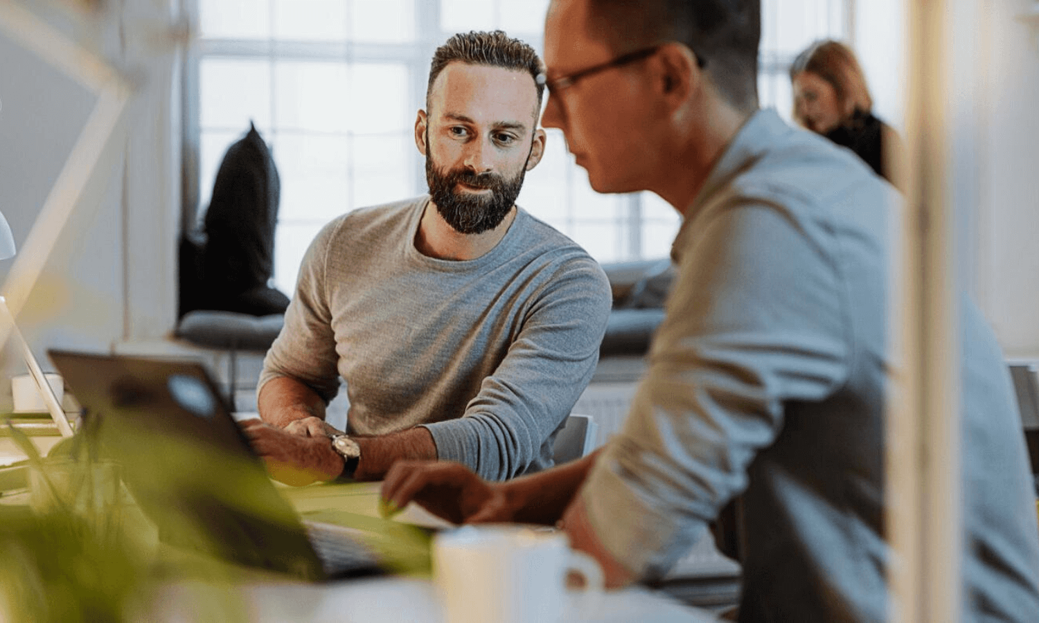 Colleagues looking at laptop in office sending secure email
