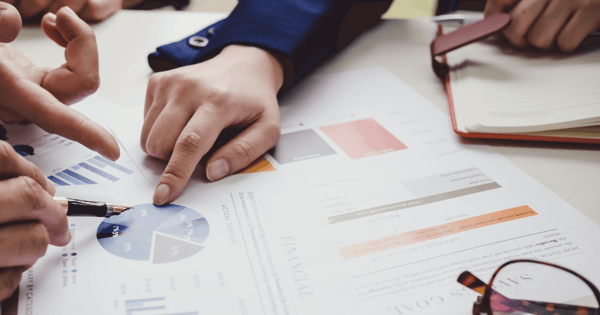 Financial adviser pointing at charts with client