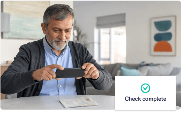 Man photographing his passport with a smartphone, with a Mailock identity check complete confirmation