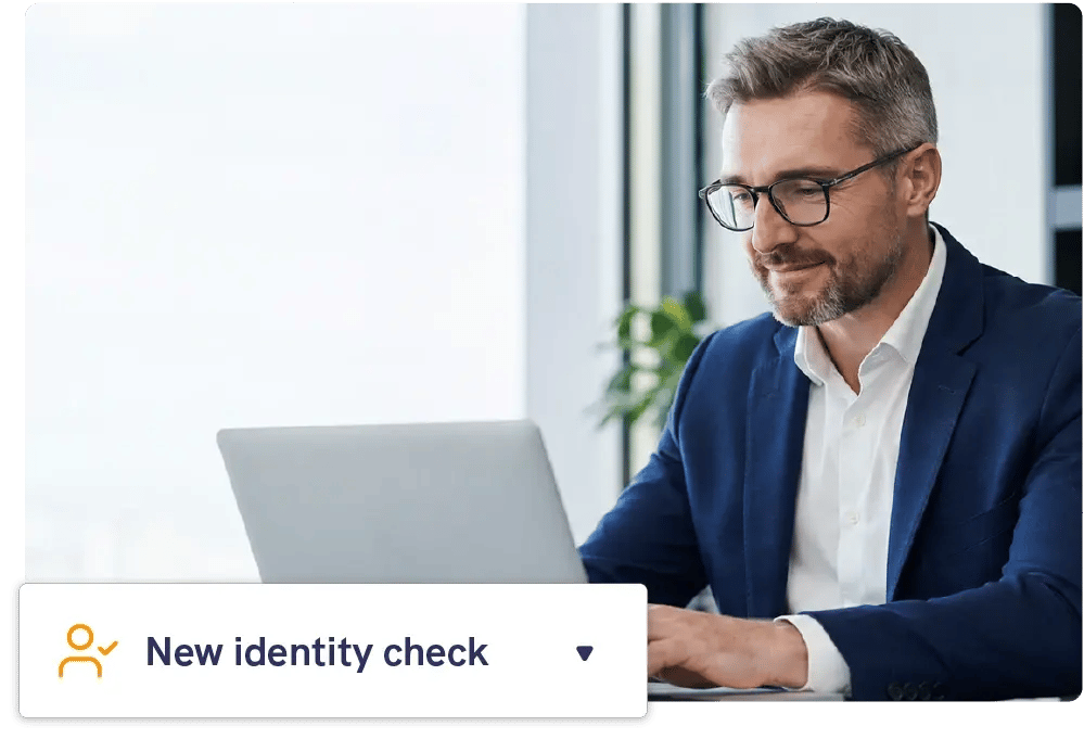 A professional working at a laptop in an office, with a New identity check panel from Mailock