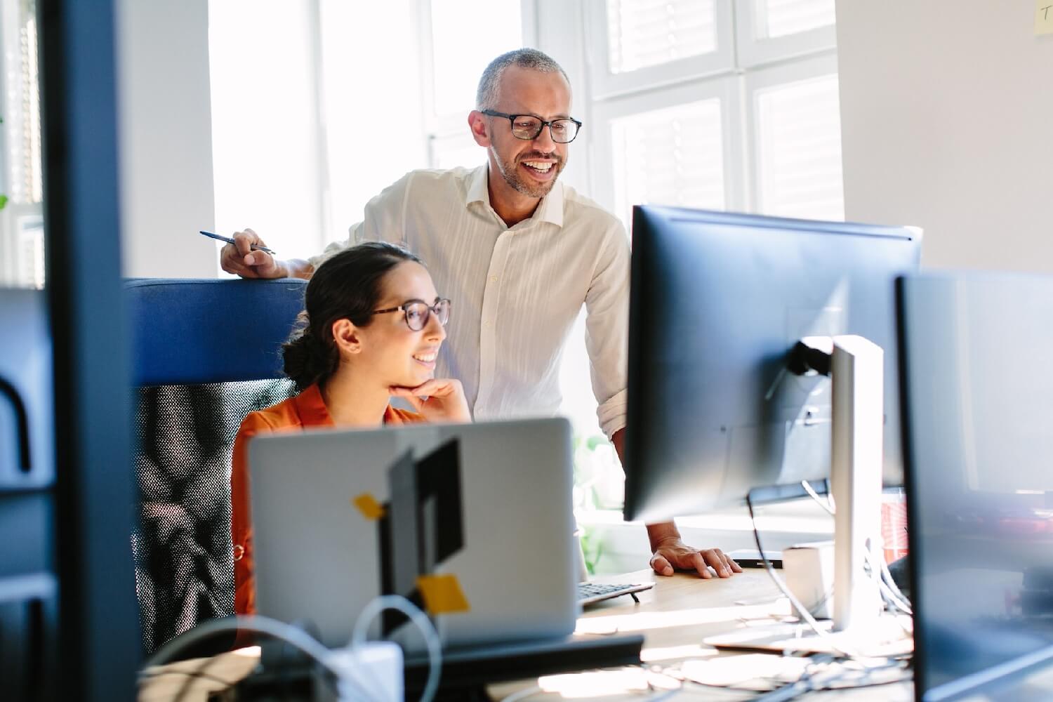 Male professional helping his colleague to use their secure email system