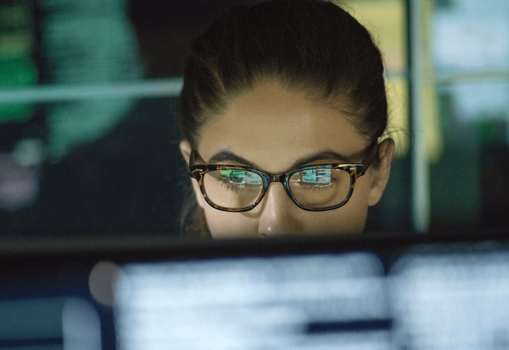 Woman looking at computer screen through glasses at secure email usage dashboard