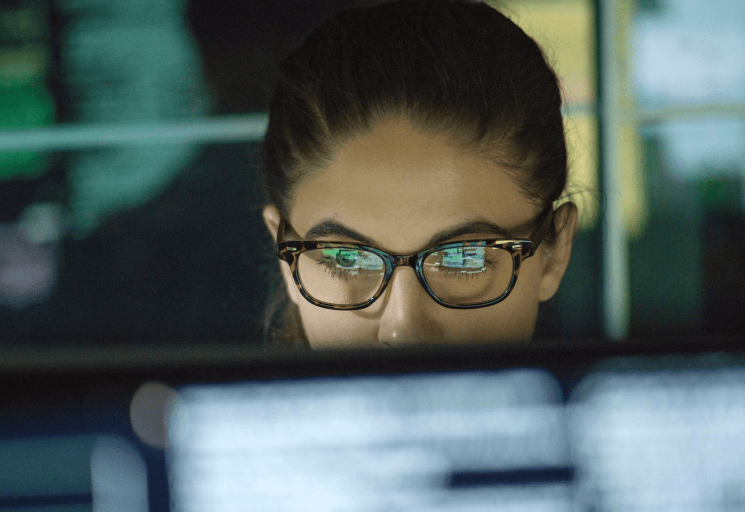 woman looking at computer screen through glasses
