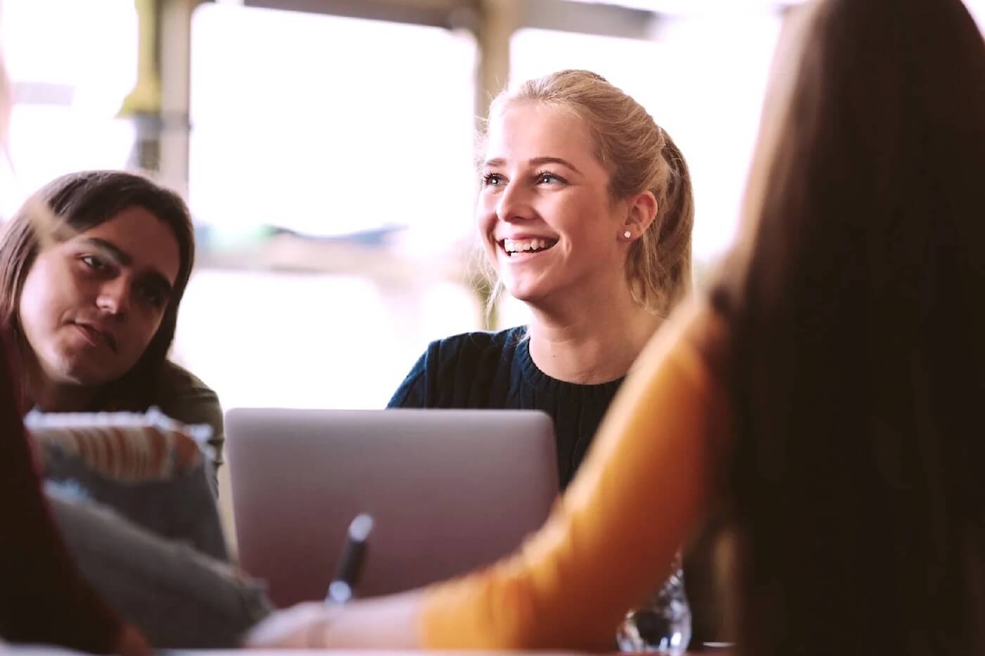 Woman smiling in office with colleagues